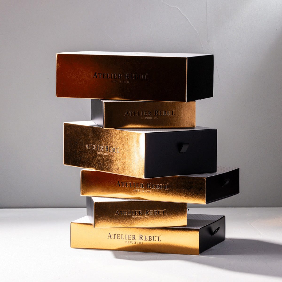 frontansicht aufeinandergestapelter unterschiedlicher istanbul gift sets, die wie gold schimmernde bloecke aussehen.