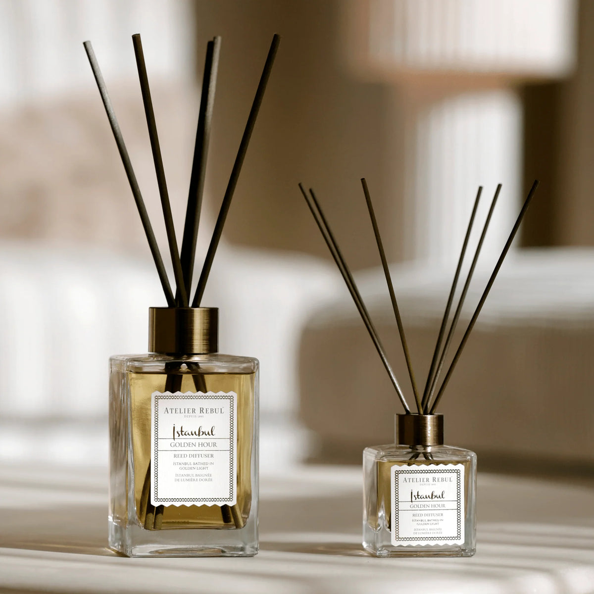 Atelier Rebul Istanbul Golden Hour Raumdiffusor 515 ml mit Duftstäbchen neben der kleineren Variante im Größenvergleich.