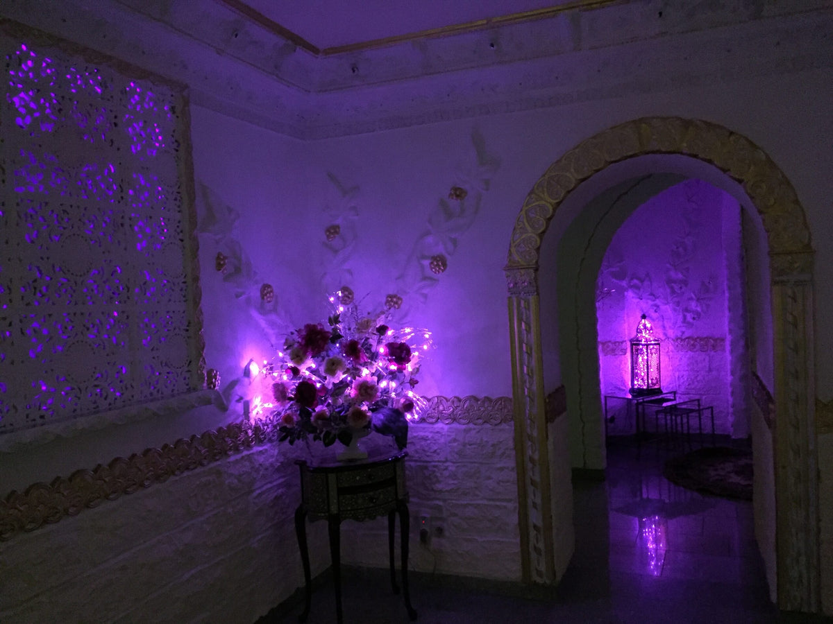 Orientalischer Ruhebereich im Mathilden Hamam mit violettem Licht, Blumen und Torbogen