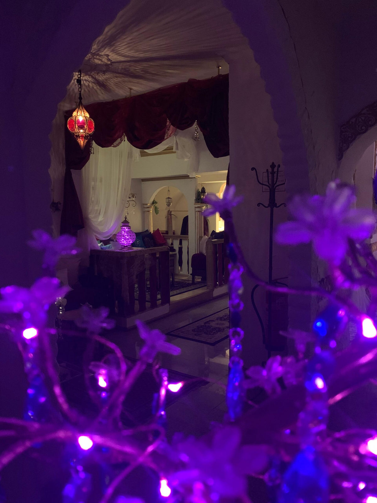 Stimmungsvolle Hamam-Lounge mit violettem Licht, orientalischem Torbogen und gemütlicher Atmosphäre