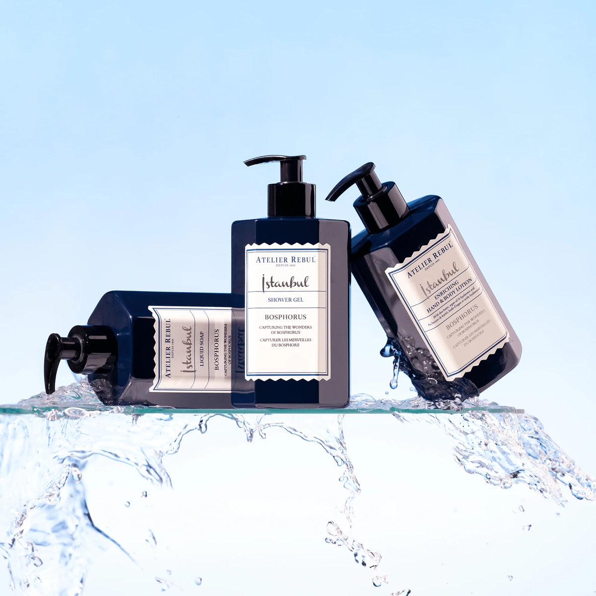 Atelier Rebul Istanbul Bosphorus Duschgel 400 ml zwischen Flüssigseife und Körperlotion auf einer Glasablage mit Wasserspritzern.