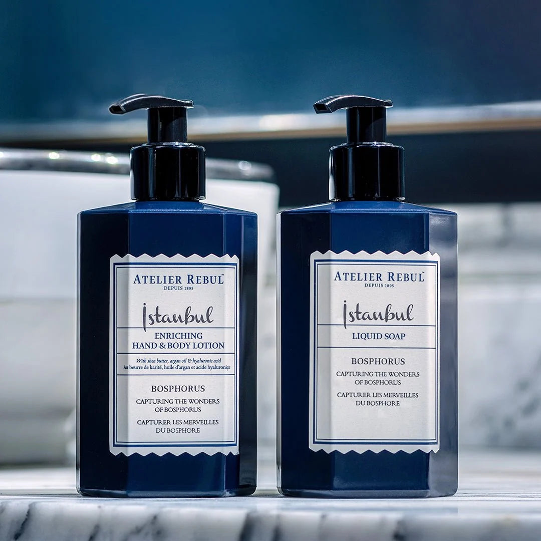 Atelier Rebul Istanbul Bosphorus Flüssigseife und Hand- und Körperlotion in dunkelblauen Pumpflaschen auf einer Marmorablage.