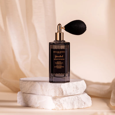 Atelier Rebul Istanbul Extrait de Parfum 50 ml im dunklen Glasflakon mit Ballonzerstäuber auf hellen Steinplatten.