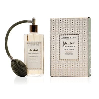 Atelier Rebul Istanbul Golden Hour Eau de Parfum 125 ml im Glasflakon mit olivgrünem Ballzerstäuber neben gemusterter Verpackung auf weißem Hintergrund.