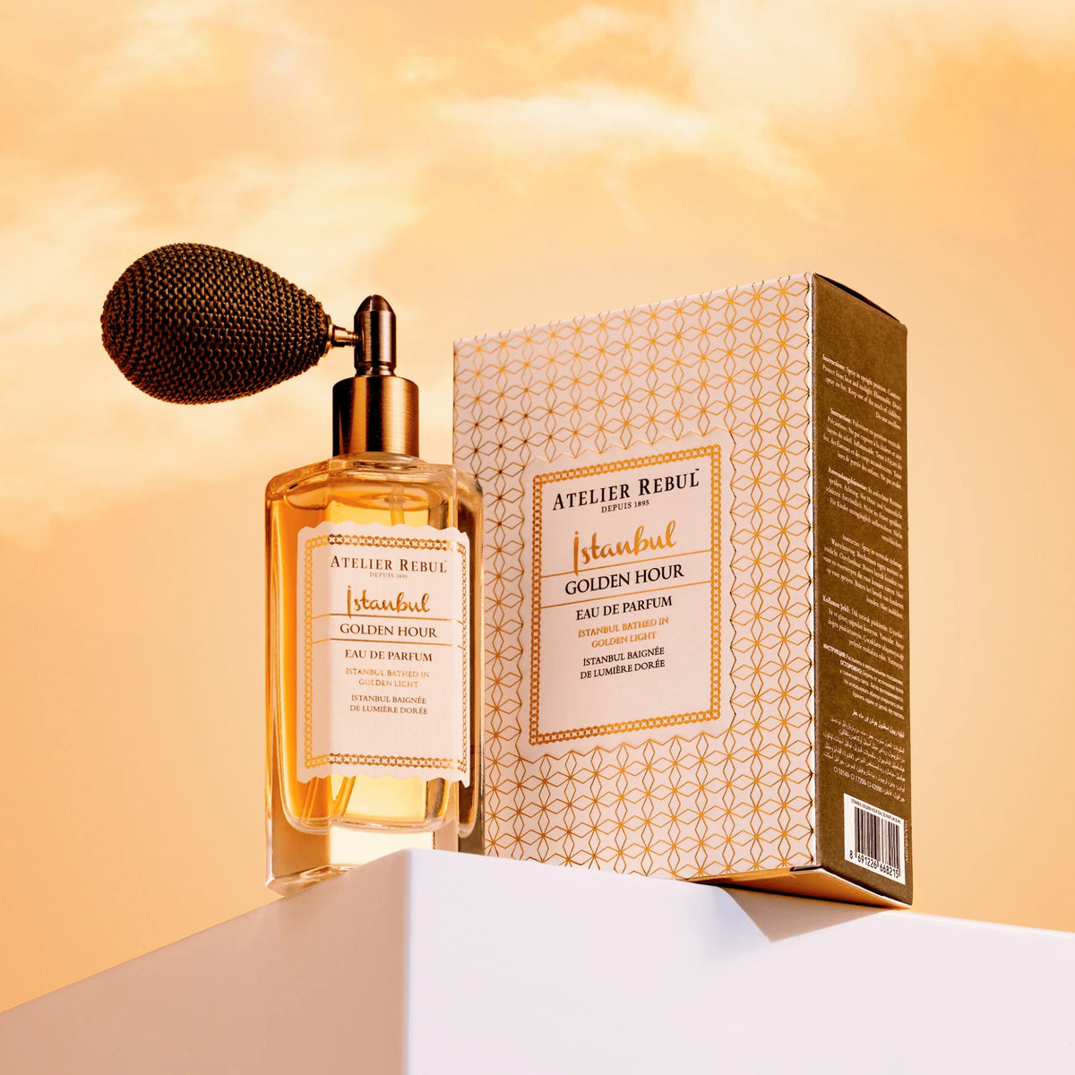 Atelier Rebul Istanbul Golden Hour Eau de Parfum 50 ml mit Verpackung auf einem weißen Podest im goldenen Licht.