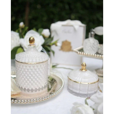 Elegante Duftkerze Jasmine Flower Tea von Côte Noire auf silbernem Tablett, umgeben von weißen Blumen und Geschenkverpackung