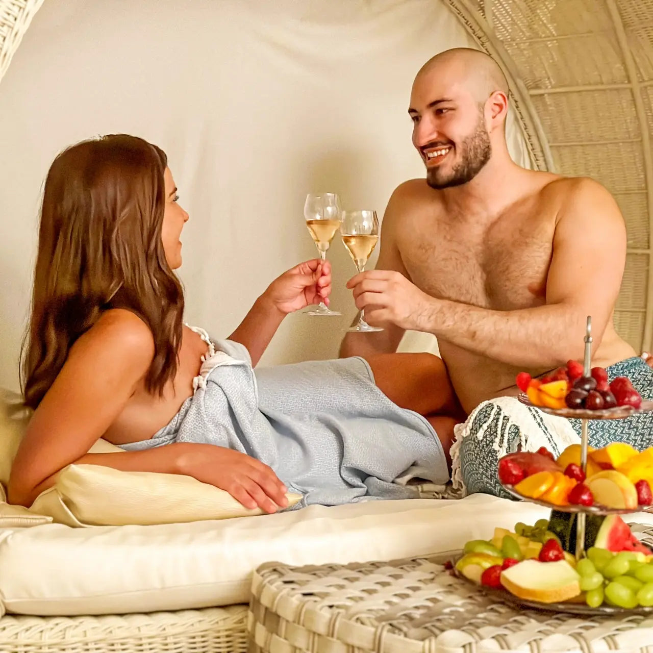 Paar entspannt im Ruheraum des Hamam mit Sekt und frischem Obst – Wellnessmoment zu zweit