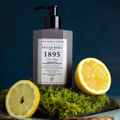 1895 hand und koerperlotion in 250ml grauer kunststoffflasche mit pumpe auf moos und zitronenscheibe 