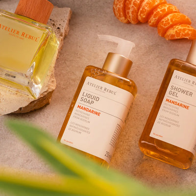 3 auf einem steinboden liegende atelier rebul produkte sind umhuellt von mandarinenstueckchen  