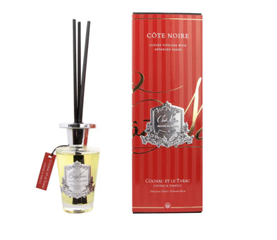 schwarze duftstaebchen im glas mit silbernem deckel und emblem. rote verpackung. cognac and tobacco.