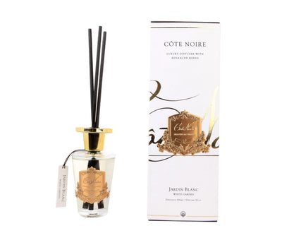 schwarze duftstaebchen im glas mit goldenem deckel und emblem. weisse verpackung. white garden.