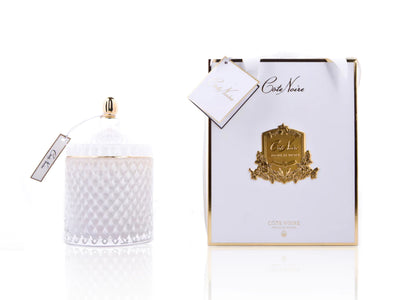 cote noire grand art duftkerze in dekorativem glas, daneben verpackung mit geschenkschleife, weiss und gold.